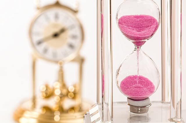Mechanical clock and hourglass show how long the different types of dermal fillers lasts