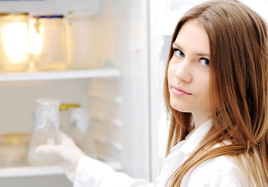 A nurse near an open refrigerator in which botulinum toxins are stored